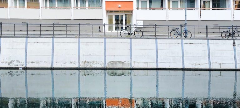 Hochhaus spiegelt sich im Fluss
